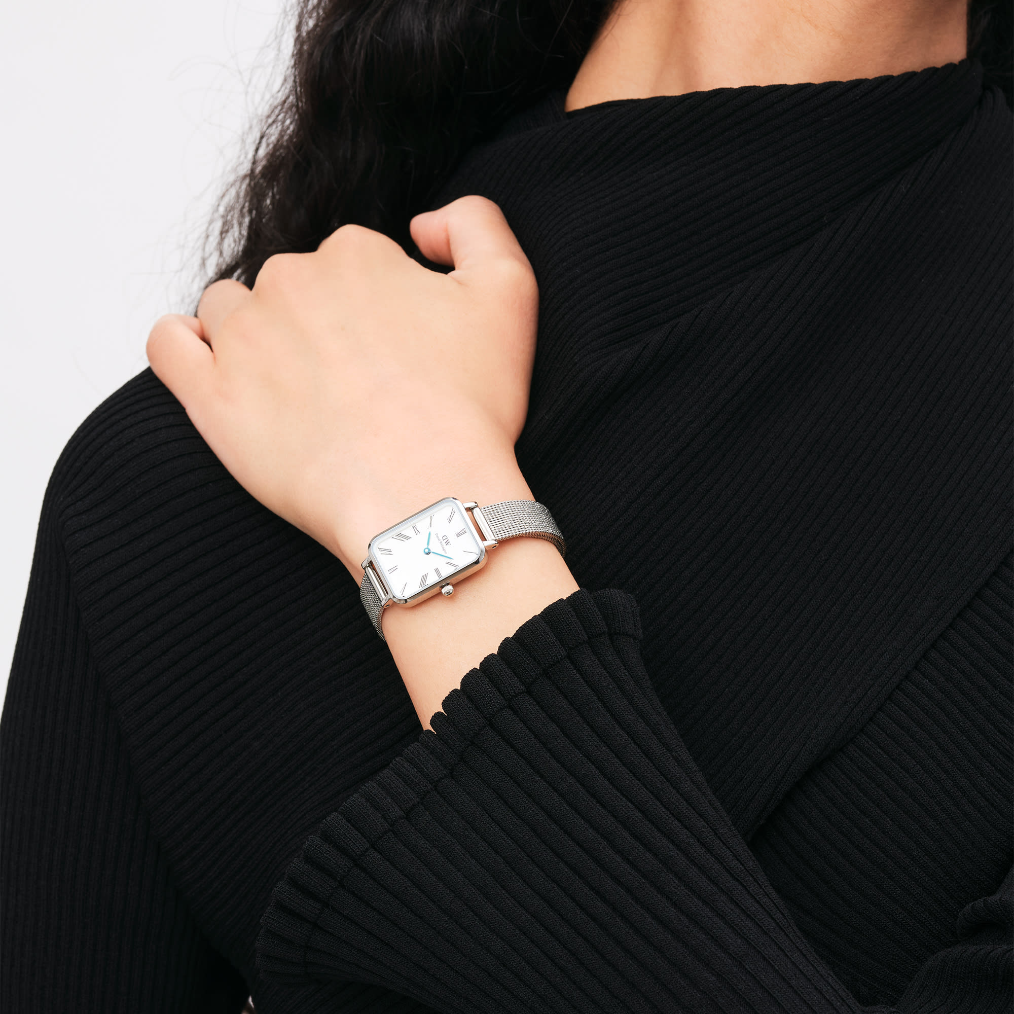 Quadro Roman numerals watch worn on wrist with silver mesh strap