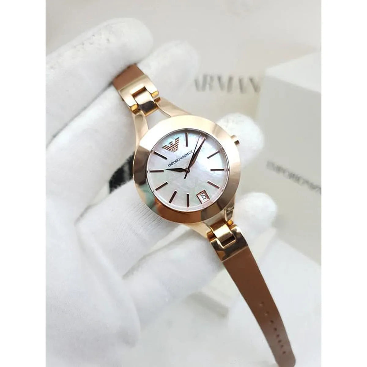 Rose gold Emporio Armani women's watch with silver dial and date window, worn on wrist