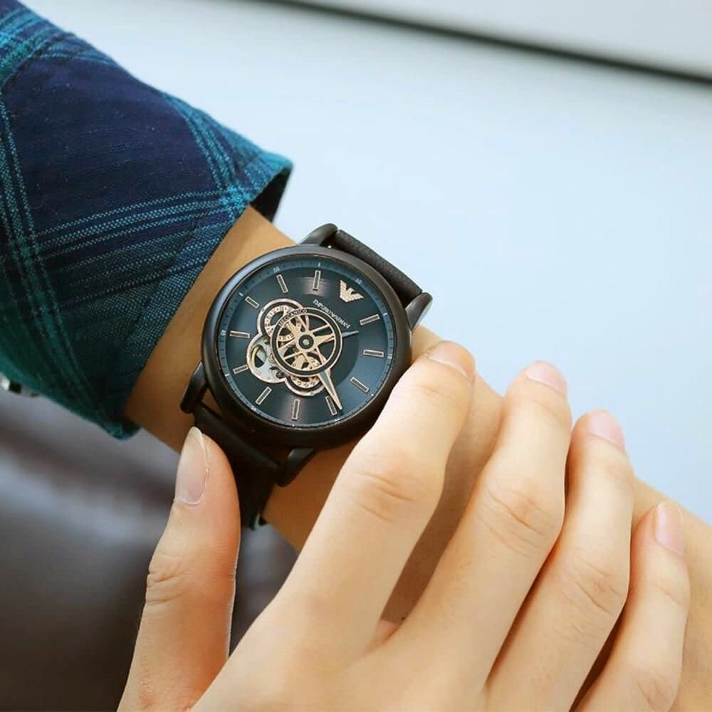 Emporio Armani Luigi skeleton watch worn on wrist with black leather strap