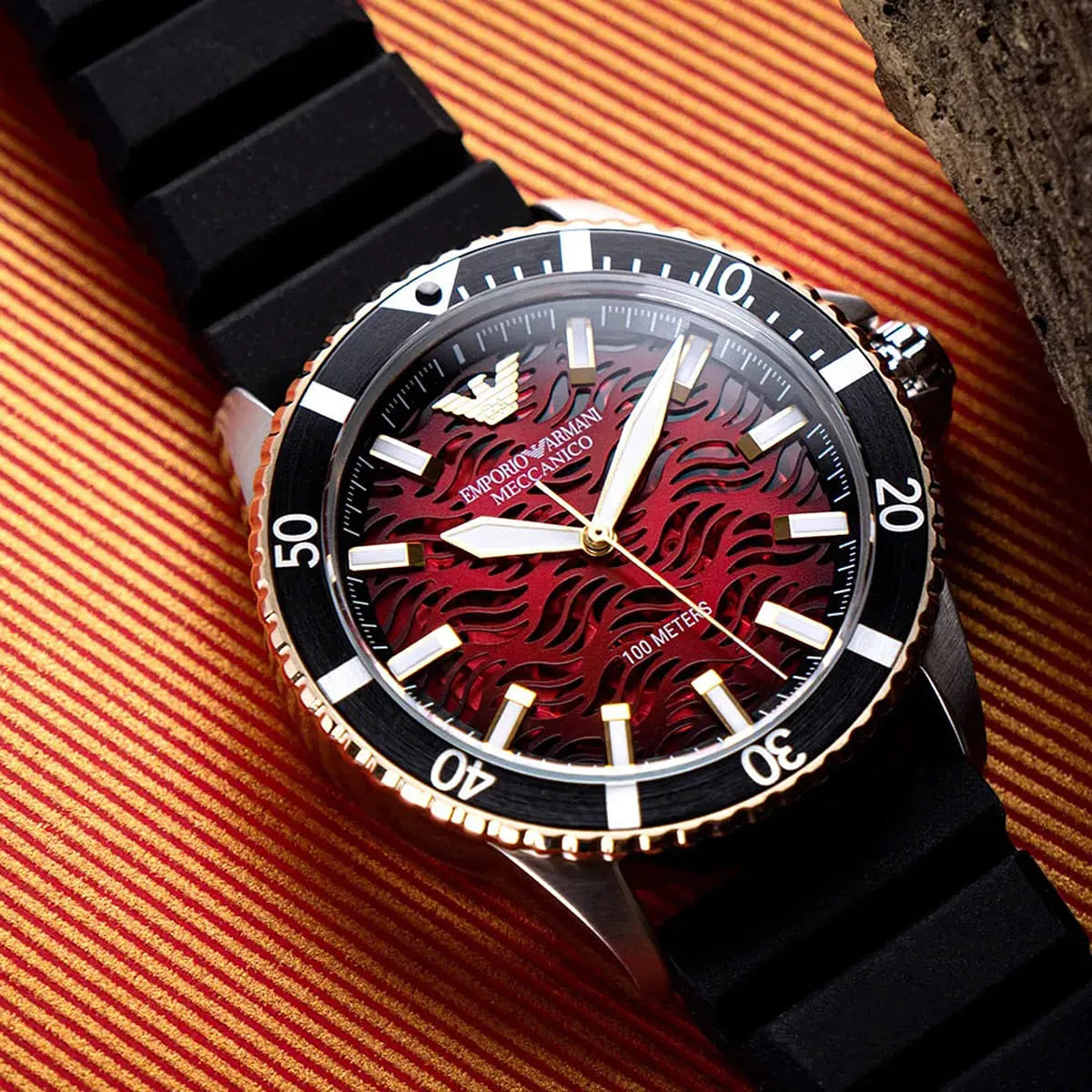Close-up of red textured wave dial with applied indices and sword hands