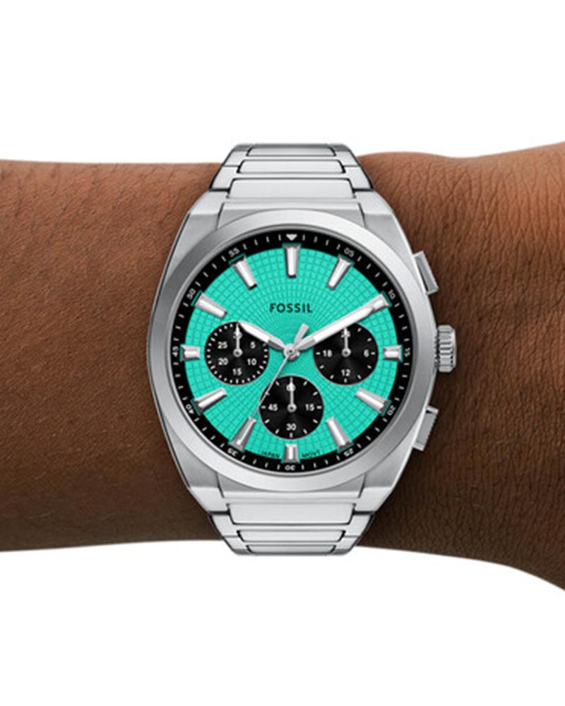 Fossil Everett chronograph worn on wrist showing turquoise dial and stainless steel bracelet