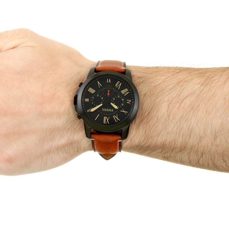 Fossil Grant chronograph men's watch worn on wrist, displaying black dial with gold accents and brown leather