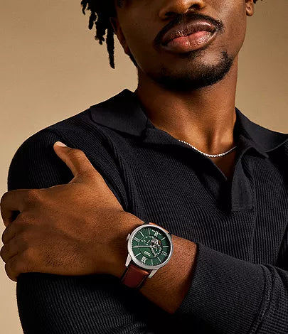 Fossil Inscriptor men's watch worn on wrist with green dial and brown leather strap