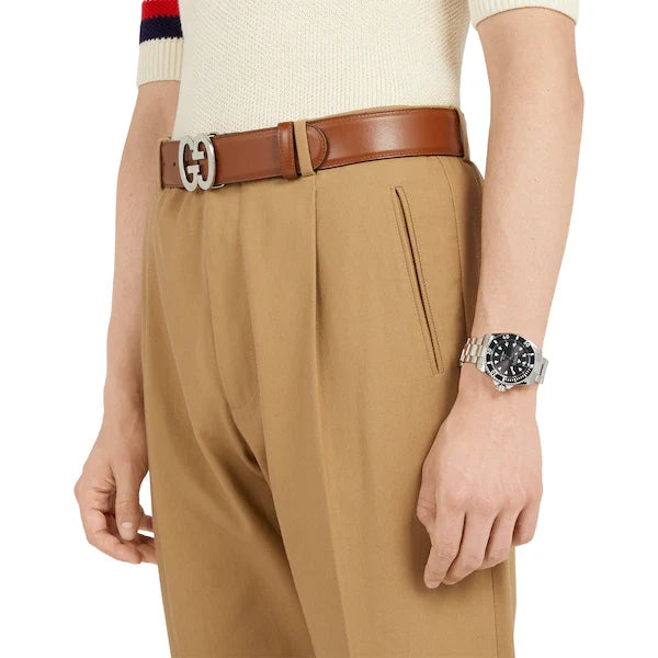 Gucci Dive watch on wrist with black dial and stainless steel bracelet worn on arm