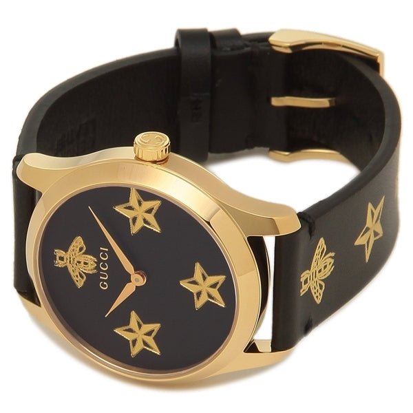 Gucci G-Timeless watch on wrist showing black dial with gold stars and bee motifs