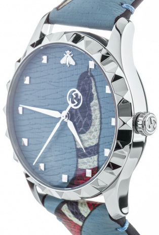 Side angle view of Gucci G-Timeless watch showing blue dial, kingsnake print strap, and steel case