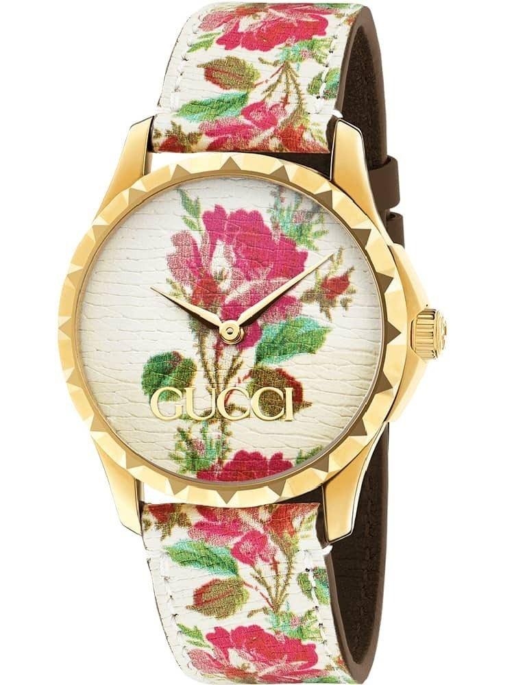 Gucci G Timeless watch three-quarter view showing floral dial and white leather strap