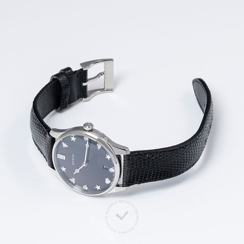 Gucci G-Timeless watch on wrist showing black mother of pearl dial and black leather strap