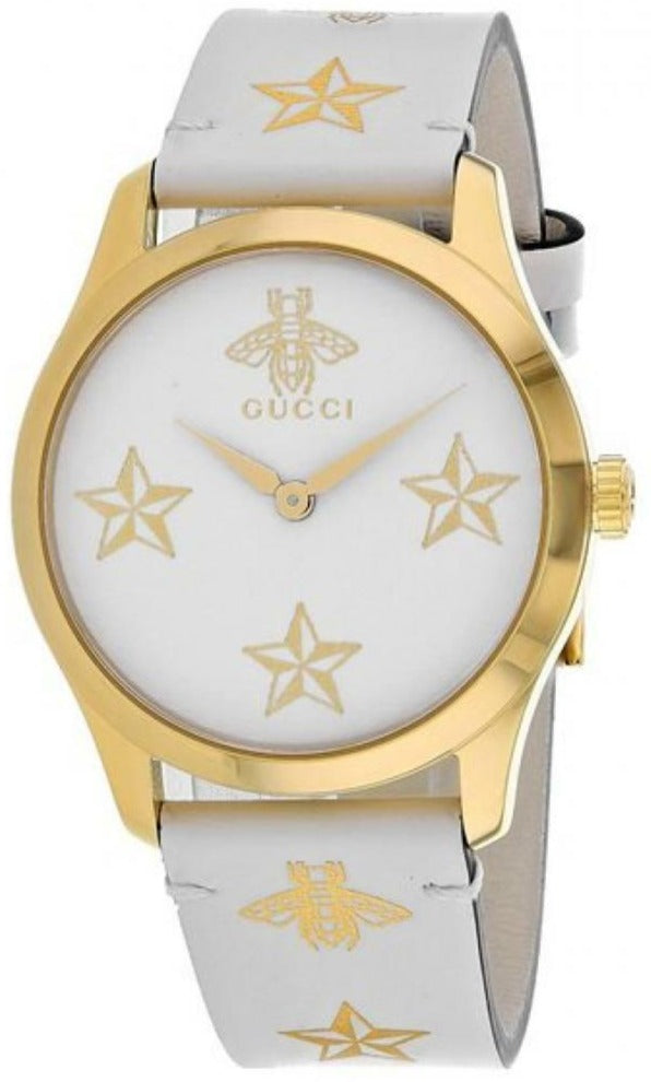 Side angle view of Gucci G-Timeless watch showing gold case and cream leather strap