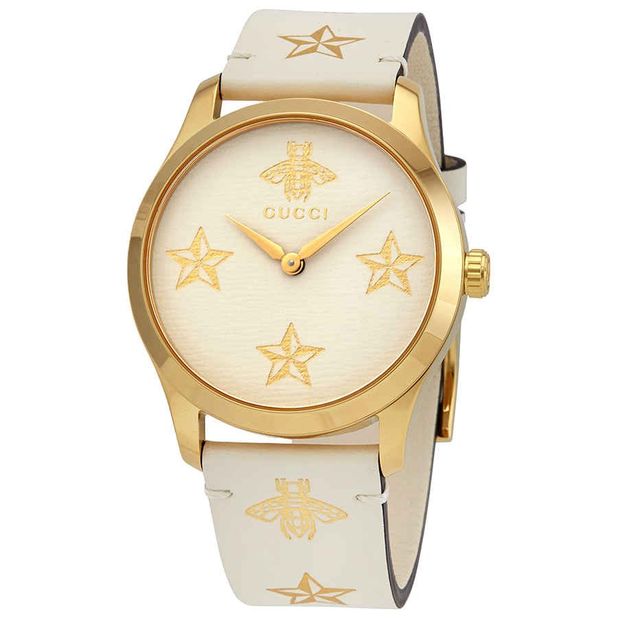 Front view of Gucci G-Timeless watch dial with stars, bee motif, and gold-tone hands
