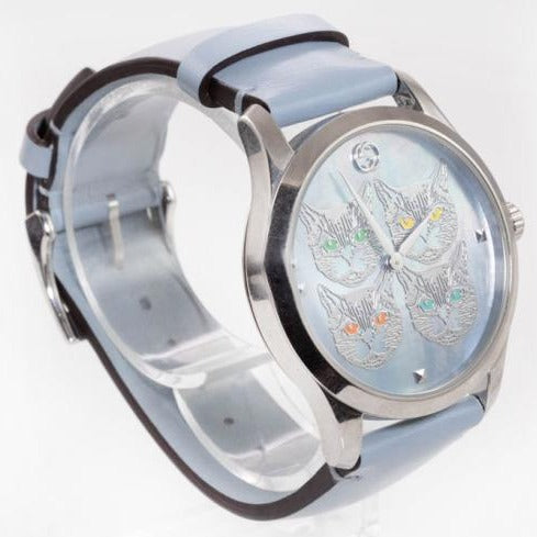 Side profile of G-Timeless watch showing silver case, light blue leather strap, and dial