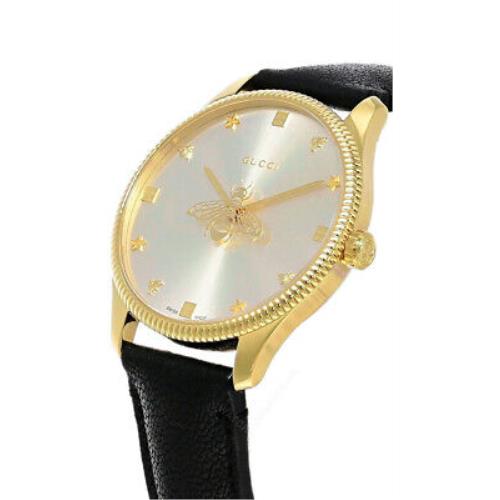 G-Timeless yellow gold case with silver dial and bee design, angled view with black strap