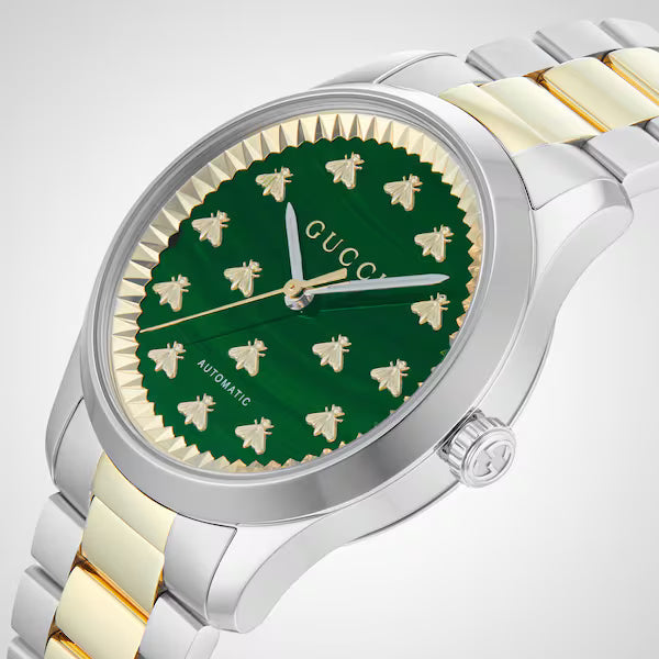 Close-up of Gucci G-Timeless malachite dial with gold bee indices and applied logo