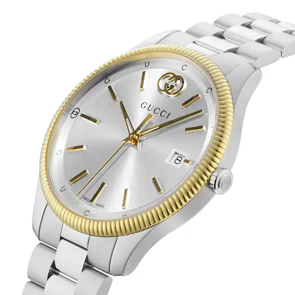 Angled view of Gucci G-Timeless watch with silver dial and gold-tone hour markers