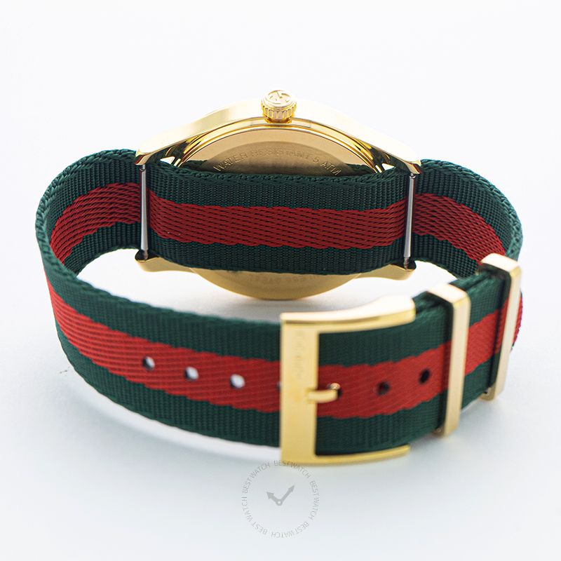 G-Timeless watch from rear showing gold caseback and striped nylon strap with buckle