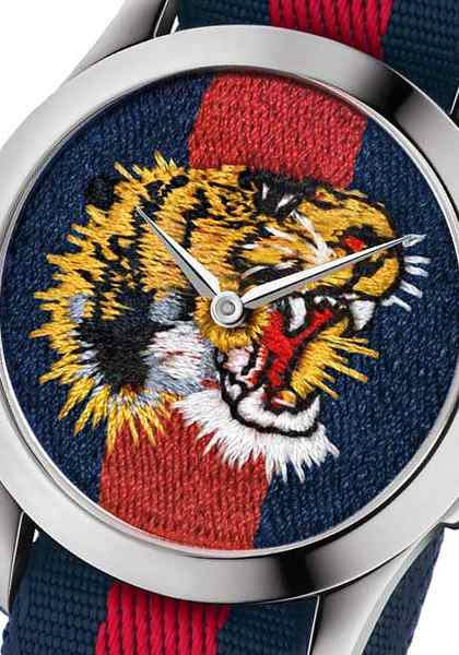 Close-up of Gucci G Timeless dial featuring embroidered tiger head in gold, white, and red