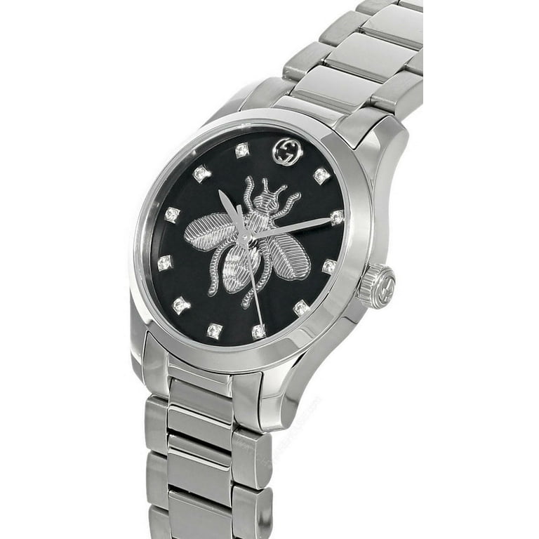 Angled view of Gucci G-Timeless watch showing black dial with bee design and stainless steel three-link bracelet