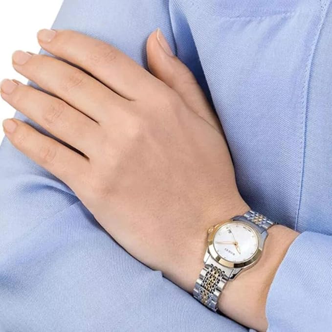 Gucci G-Timeless watch worn on wrist showing mother of pearl dial and two-toned steel bracelet
