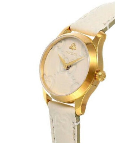 Gucci G-Timeless watch side profile showing gold case and white leather strap