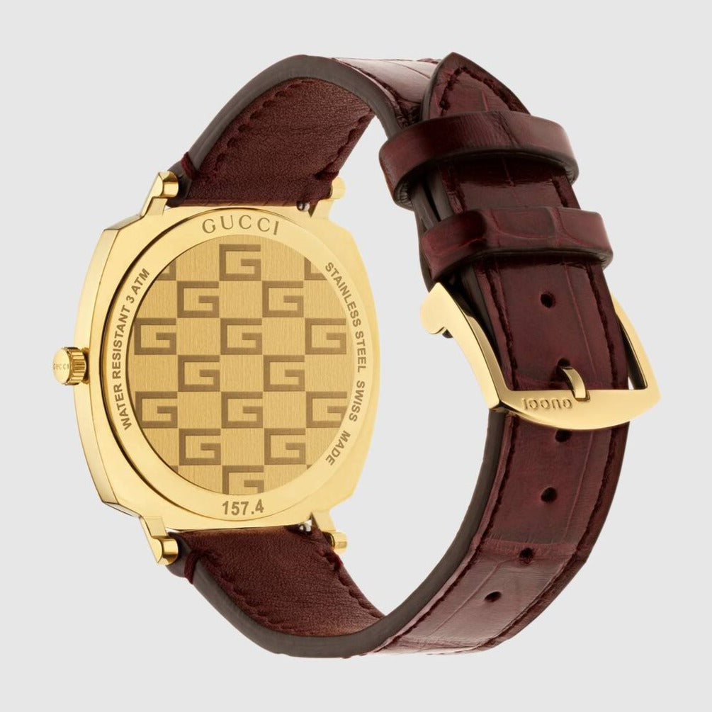 Gucci Grip YA157413 watch worn on wrist showing gold case with GG pattern dial and burgundy strap