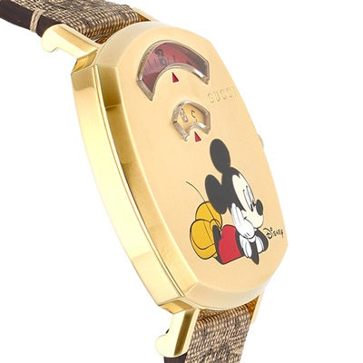 Angled view of Gucci Grip watch displaying gold case, Mickey Mouse dial illustration, and brown leather strap