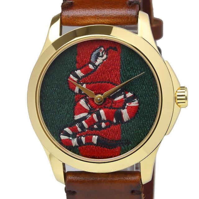 Close-up of Gucci snake dial with green and red embroidered design and gold hands