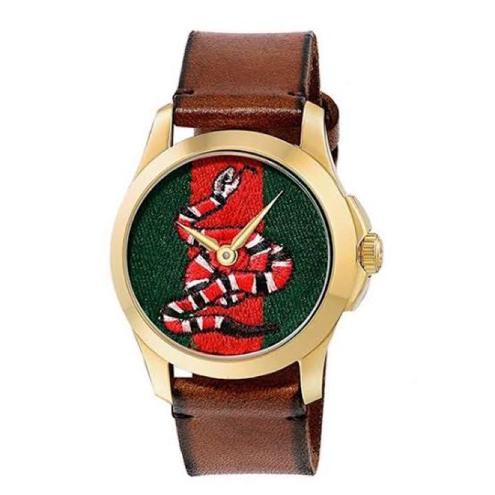 Front view of Gucci snake watch with gold-tone case and brown leather strap