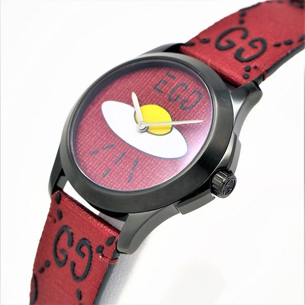 Gucci YA1264023 men's watch worn on wrist with red UFO dial and fabric strap
