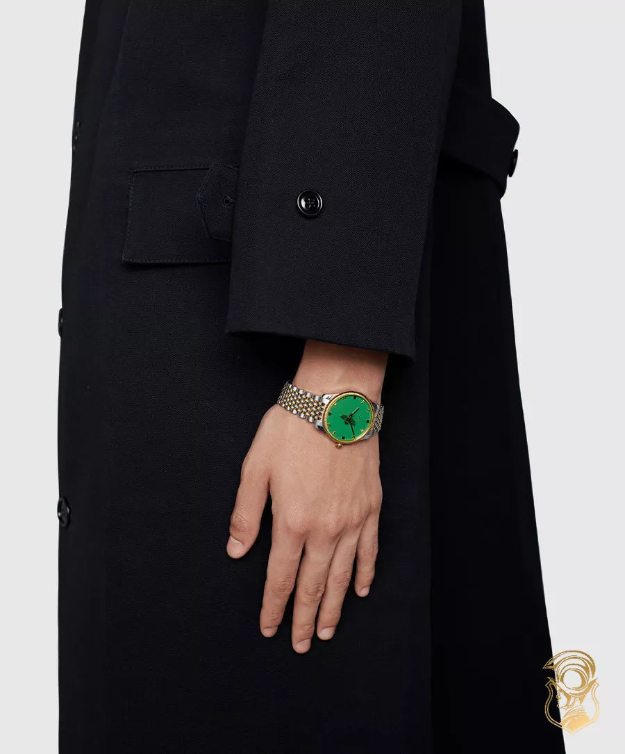 Gucci G Timeless green dial watch worn on wrist with two-tone strap