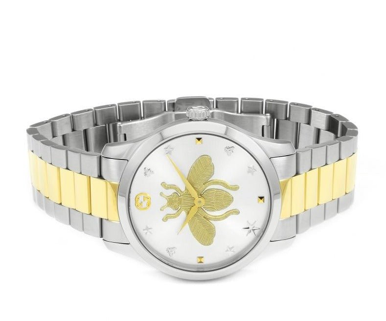 Overhead angle view of Gucci G-Timeless YA126599 watch displaying silver bee dial and two-tone bracelet