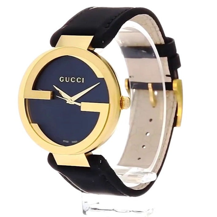 Gucci Interlocking G watch at angle showing gold case and black leather strap