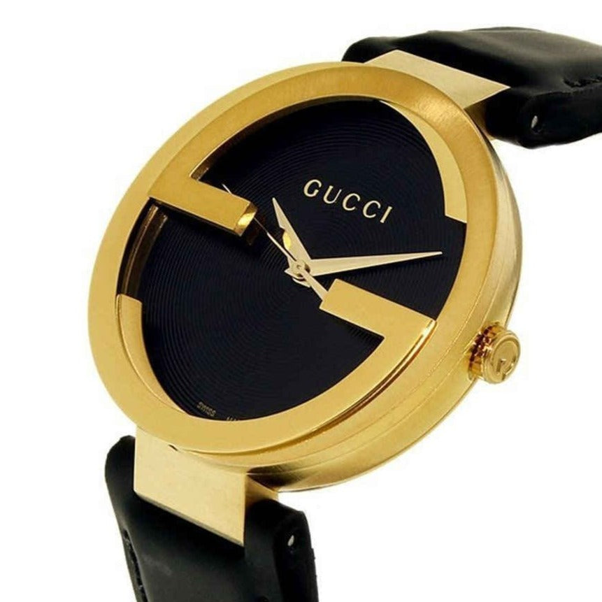 Close-up of Gucci Interlocking G dial with black textured surface and gold hands