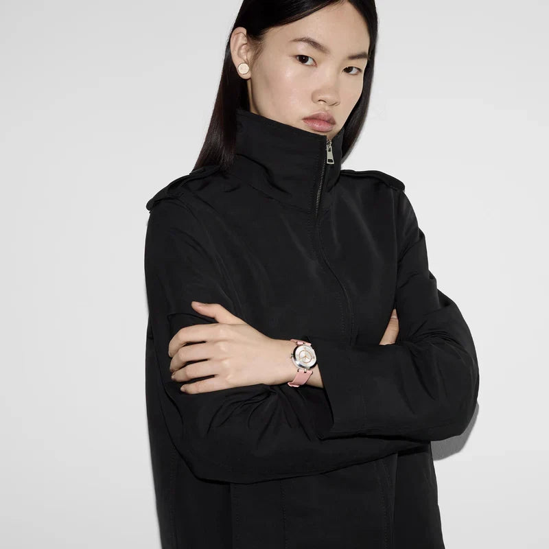 Gucci watch worn on wrist showing silver case and pink leather strap
