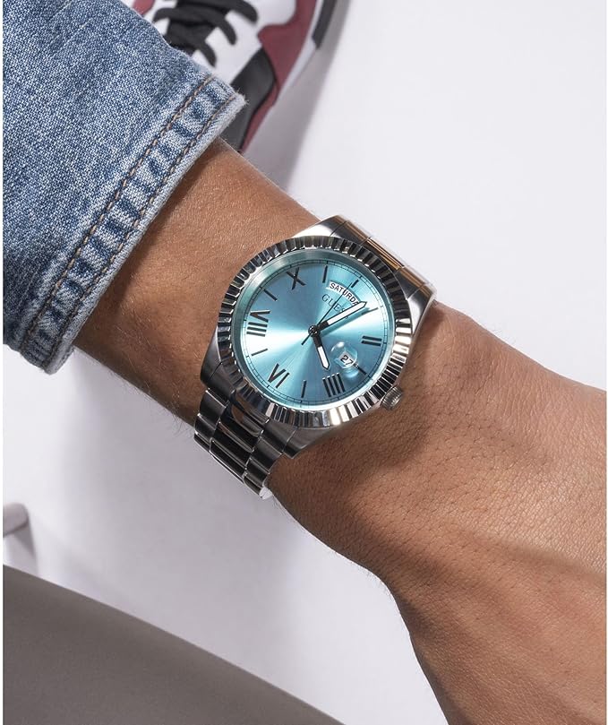 Guess Connoisseur watch worn on wrist with turquoise dial and silver steel bracelet