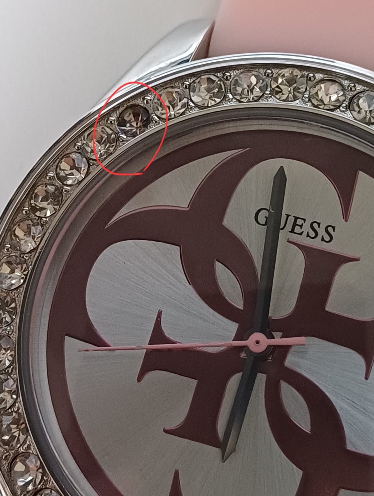 Guess G-Twist dial close-up showing pink and silver G-logo design with crystal bezel and hands