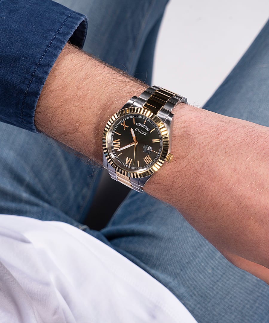 Guess GW0265G8 watch worn on wrist showing green dial and two-tone metal bracelet