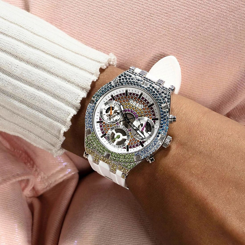 Guess GW0407L4 worn on wrist against pink fabric, crystal bezel visible