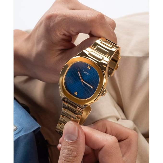 Angled view of Guess HEADLINE watch with blue dial and gold-tone bracelet