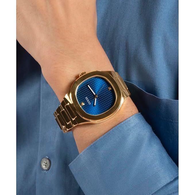 Guess HEADLINE watch worn on wrist with blue dial and gold-tone case