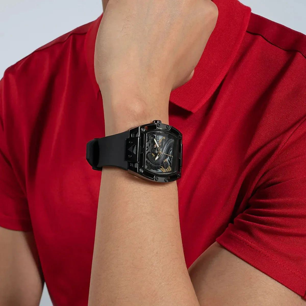 Guess Legend black watch worn on wrist with red shirt in background