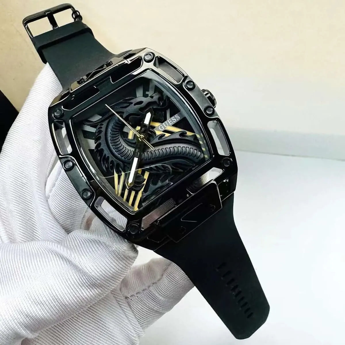 Guess Legend black rectangular watch on wrist held in hands with white gloves