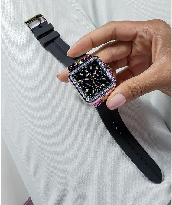 Guess Libra watch on wrist displaying black dial with gold-tone hands and indices