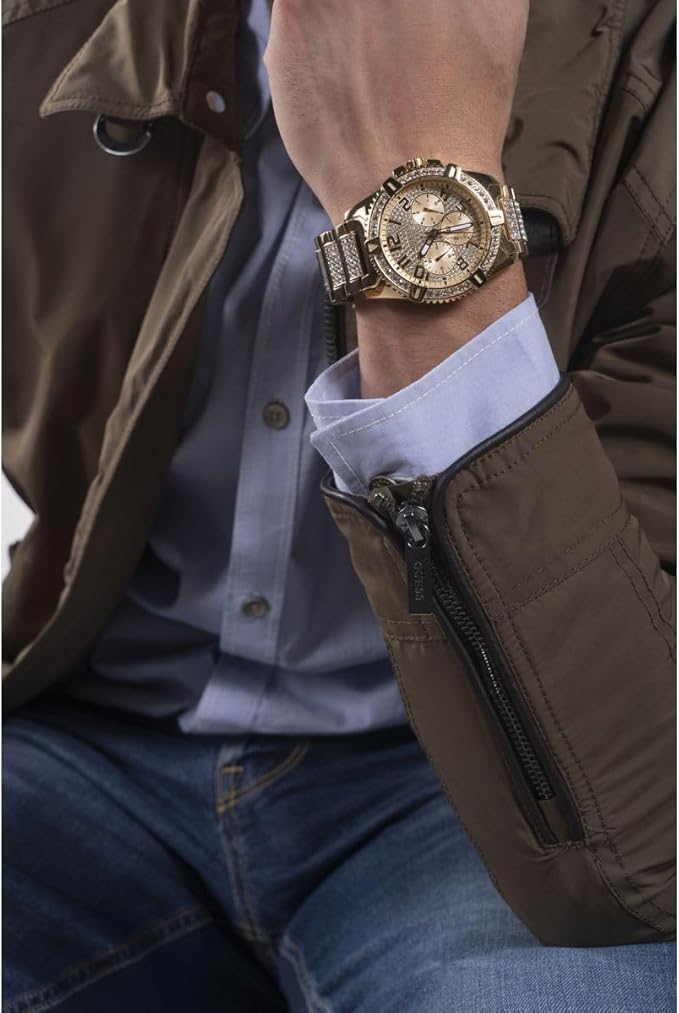 GUESS W0799G2 gold chronograph watch worn on wrist with brown jacket sleeve