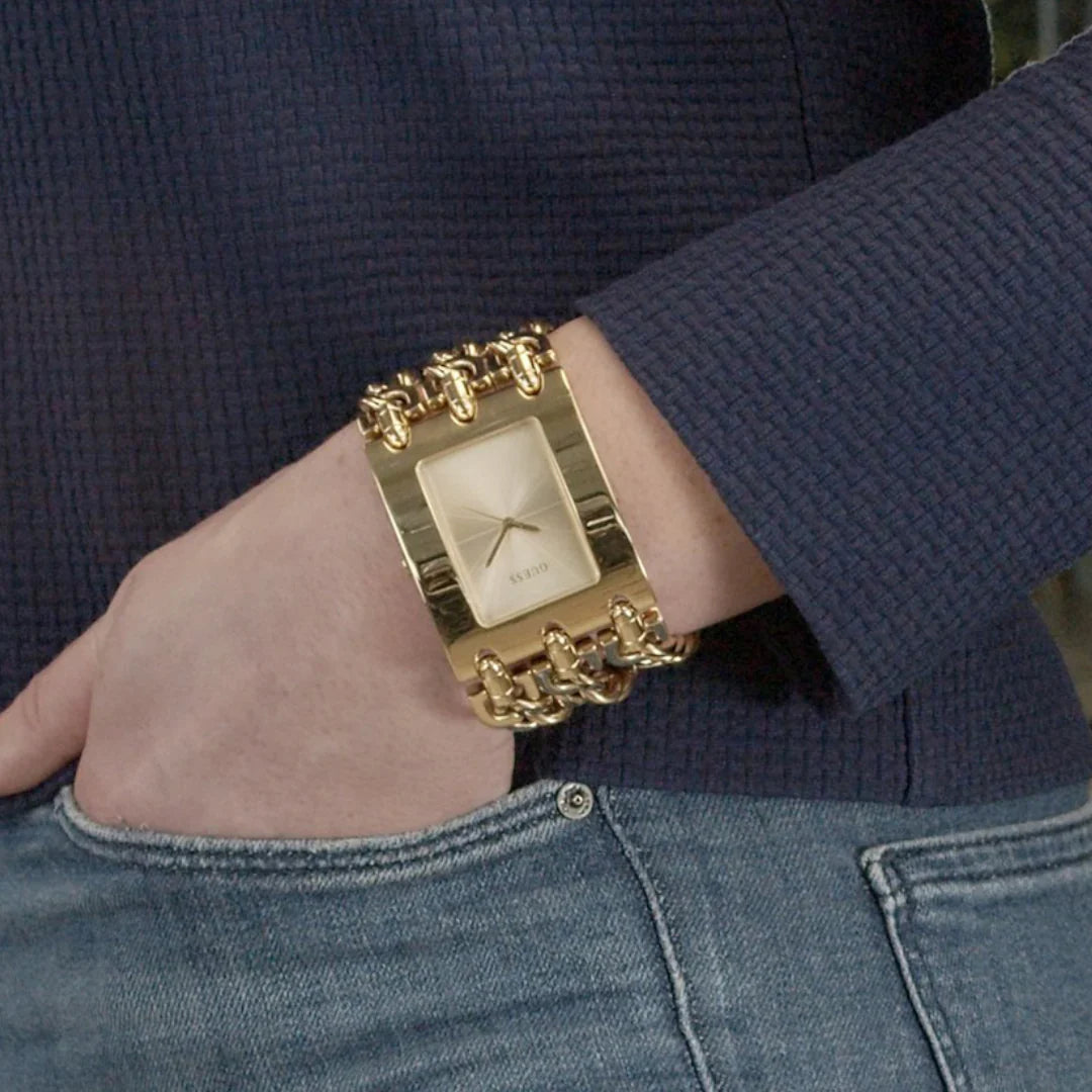 Guess W1274L2 gold watch worn on wrist, showing rectangular face and chain link strap