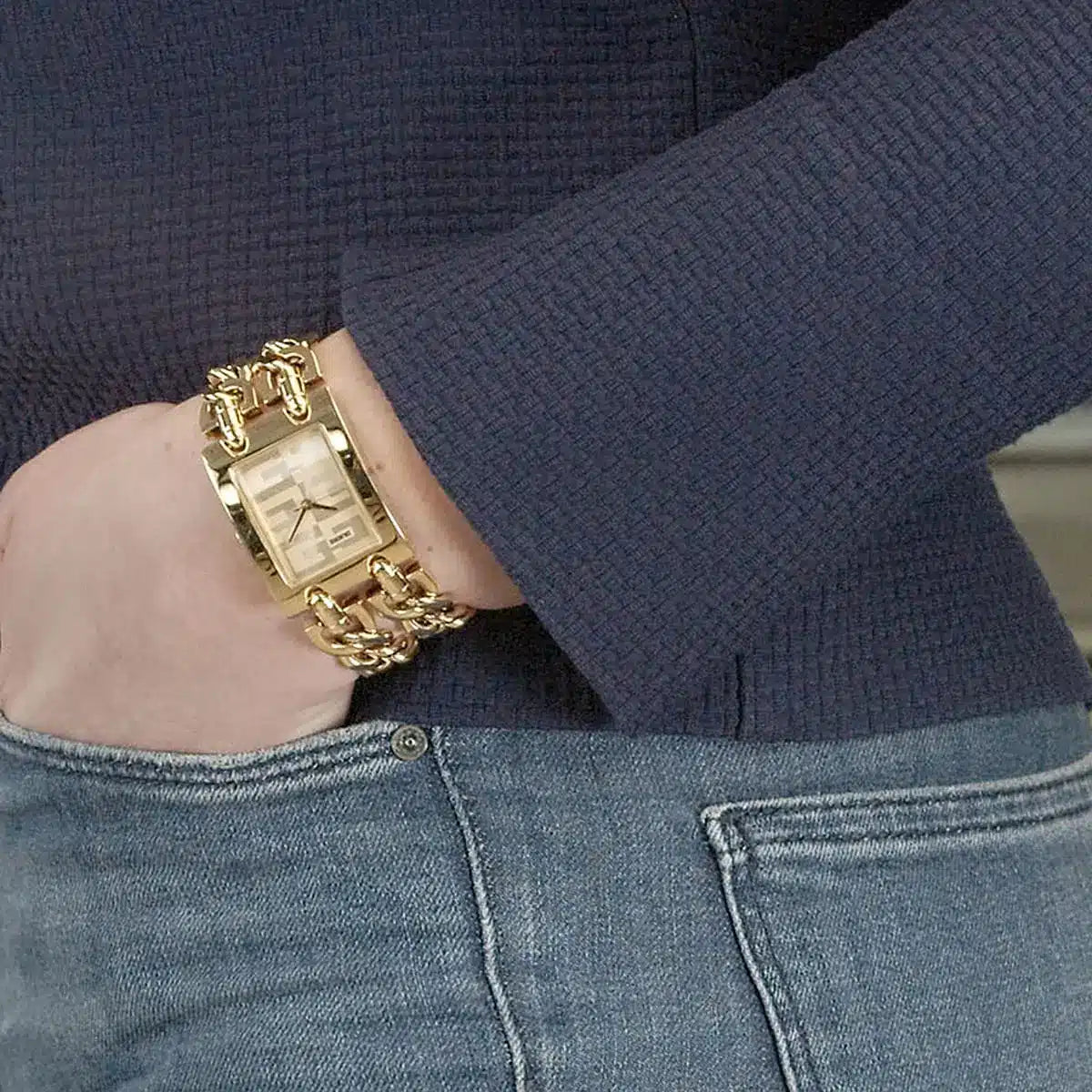 Guess G Mod gold watch worn on woman's wrist