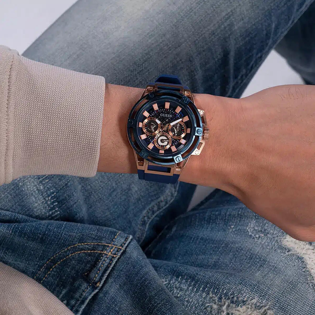 Guess Matrix men's watch on wrist with blue rubber strap and rose gold case details