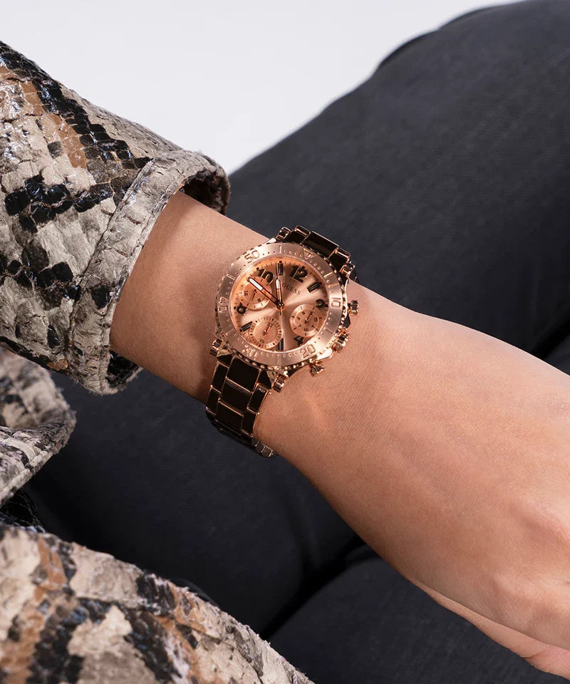 Guess Cosmic rose gold watch worn on wrist with snake print sleeve