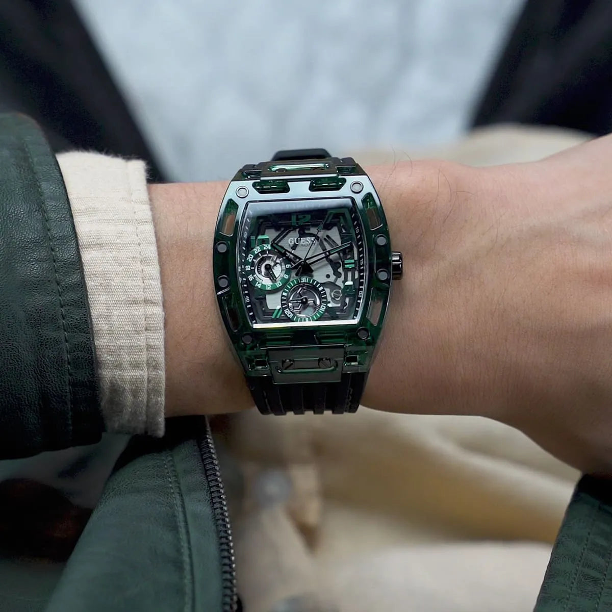 GUESS GW0499G7 men's watch detail view showing green tonneau case with skeleton movement