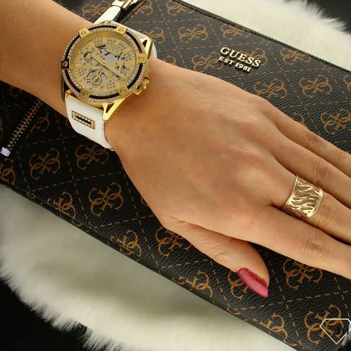 GUESS GW0536L2 multi-function watch worn on wrist with white strap and gold dial