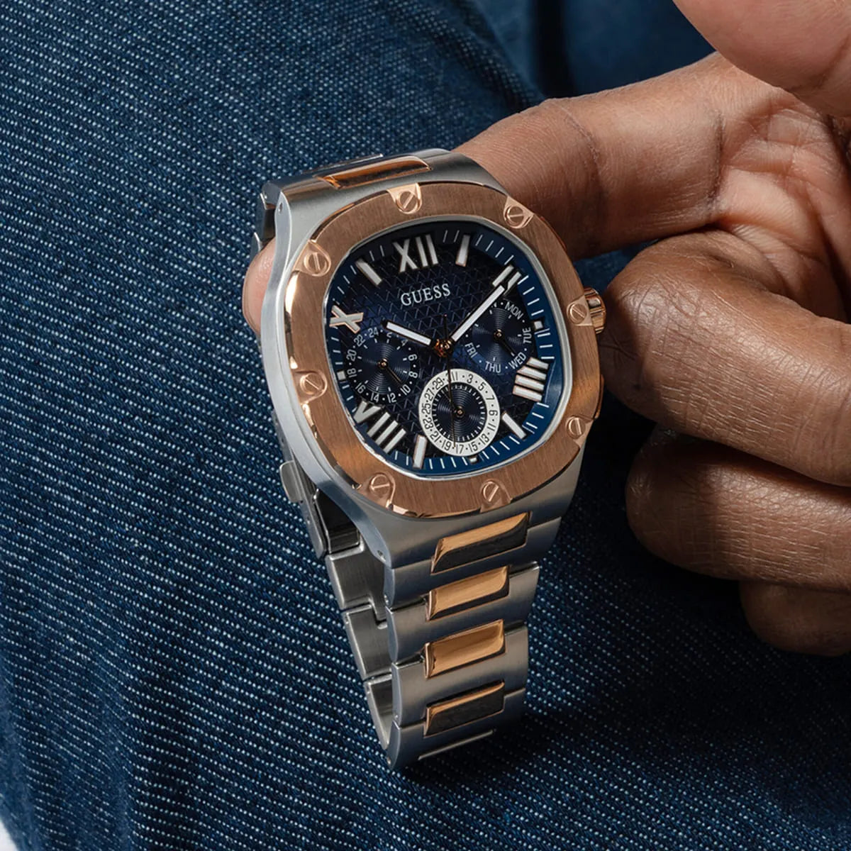 Side profile of Guess Headliner watch with chronograph pushers and two-tone bracelet